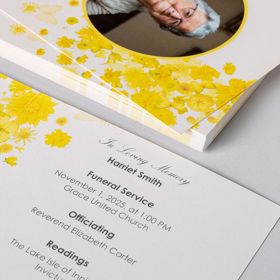 Close view of a memorial service program in a yellow floral design, opened to the printed order of service