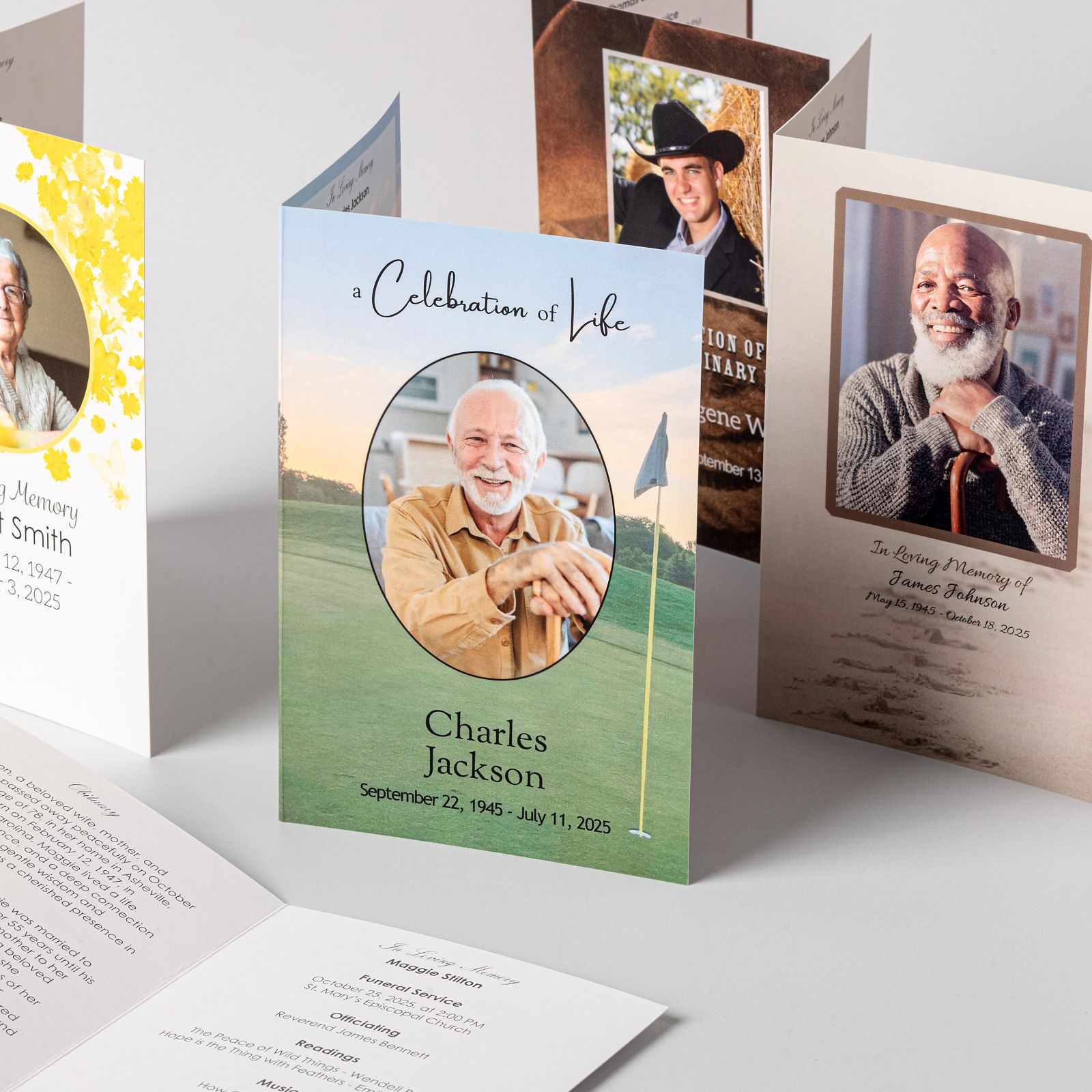 Several folded memorial service programs standing upright in different designs, one reading A Celebration of Life above a photograph, name, and dates