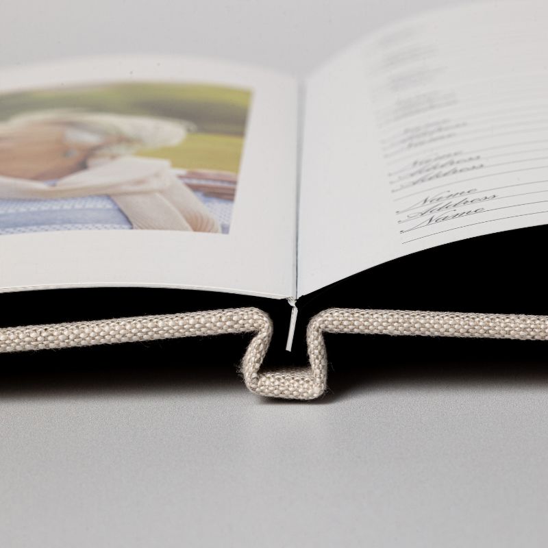 Close view of the hinged binding that lets a linen memorial registration book lie completely flat when it is opened for signing