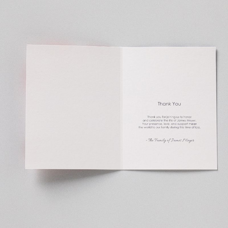 A memorial thank you card opened flat, printed inside with a message of thanks signed by the family