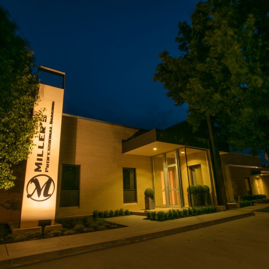 The Miller's Professional Imaging lab in Pittsburg, Kansas at dusk, its tall Miller's sign lit beside the entrance